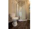 Bathroom featuring a corner shower with glass doors and dark wood flooring at 1530 Villa Capri Cir # 302, Odessa, FL 33556