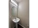 Cozy half bathroom features pedestal sink, oval mirror, and modern lighting at 1530 Villa Capri Cir # 302, Odessa, FL 33556