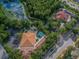 Aerial view of community buildings, a pool and playground surrounded by trees and a street with passing cars at 17616 Nathans Dr, Tampa, FL 33647