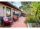 Cozy back patio with red cushioned rocking chairs and beautiful landscaping at 1823 Atrium Dr, Sun City Center, FL 33573