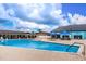 Another view of a community pool with shaded seating areas, offering a refreshing escape for residents at 1823 Atrium Dr, Sun City Center, FL 33573