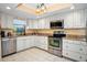 A traditional kitchen featuring stainless steel appliances, granite countertops, and white cabinetry at 1823 Atrium Dr, Sun City Center, FL 33573