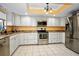 Galley kitchen features stainless steel appliances, light countertops, and tile flooring at 1823 Atrium Dr, Sun City Center, FL 33573