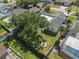 Landscaped backyard featuring a well-maintained lawn, mature trees, and a cozy fire pit area at 1849 Del Robles Dr, Clearwater, FL 33764