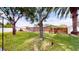 Lush backyard with a manicured lawn and mature trees provides ample shade at 1849 Del Robles Dr, Clearwater, FL 33764