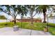 Well-maintained backyard with a patio, grassy area, string lights, and mature trees at 1849 Del Robles Dr, Clearwater, FL 33764