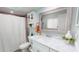 Charming bathroom featuring a marble countertop, framed mirror, and decorative wall cabinet at 1849 Del Robles Dr, Clearwater, FL 33764