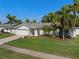 Charming single-story home with a well-maintained lawn and mature palm trees at 1849 Del Robles Dr, Clearwater, FL 33764