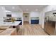 Open kitchen with stainless steel refrigerator, blue and white cabinetry, island with marble countertop, and wood floors at 1849 Del Robles Dr, Clearwater, FL 33764