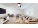 Cozy living room with a ceiling fan, light wood floors, and large windows for natural light at 1849 Del Robles Dr, Clearwater, FL 33764