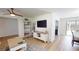 Modern living space with a view towards the dining area, featuring light wood floors and a ceiling fan at 1849 Del Robles Dr, Clearwater, FL 33764