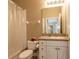 Well-lit bathroom with a vanity, toilet, shower featuring a shower curtain and accessories at 21012 Picasso Ct # 201, Land O Lakes, FL 34637