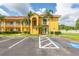 Inviting yellow condominium building with a red tile roof, palm trees, and accessible parking at 21012 Picasso Ct # 201, Land O Lakes, FL 34637
