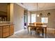 Bright dining room with a wooden table set, pendant lighting, and a passthrough view of the kitchen at 21012 Picasso Ct # 201, Land O Lakes, FL 34637