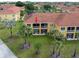 Aerial view of condominium showcasing balcony, lush landscaping, and proximity to palm trees at 21012 Picasso Ct # 201, Land O Lakes, FL 34637