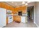 Well-lit kitchen with tile flooring, wood cabinets, and white appliances at 21012 Picasso Ct # 201, Land O Lakes, FL 34637
