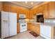 Bright kitchen featuring white appliances, wood cabinets, and tile flooring at 21012 Picasso Ct # 201, Land O Lakes, FL 34637