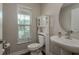Powder room featuring a pedestal sink, toilet with storage, and a window providing natural light at 21590 Violet Periwinkle Dr, Land O Lakes, FL 34637