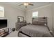 Comfortable bedroom features a ceiling fan, a dresser and a rustic wooden headboard at 21590 Violet Periwinkle Dr, Land O Lakes, FL 34637