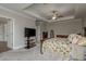 Bright bedroom with a tray ceiling, carpeted floor, television, and large bed at 21590 Violet Periwinkle Dr, Land O Lakes, FL 34637