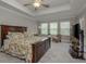 Spacious bedroom with tray ceiling, multiple windows, and a comfortable seating area at 21590 Violet Periwinkle Dr, Land O Lakes, FL 34637