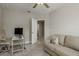 The bonus bedroom features a ceiling fan, a window and a comfortable couch at 21590 Violet Periwinkle Dr, Land O Lakes, FL 34637