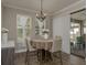 Bright dining area featuring a decorative chandelier, a table for four, and a view of the backyard at 21590 Violet Periwinkle Dr, Land O Lakes, FL 34637