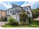 Charming two-story home featuring a well-manicured lawn and a beautifully landscaped front yard with mature trees at 21590 Violet Periwinkle Dr, Land O Lakes, FL 34637