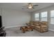 Comfortable living room featuring reclining chairs, a ceiling fan, and natural light from the window at 21590 Violet Periwinkle Dr, Land O Lakes, FL 34637