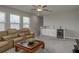 Bright, carpeted living room featuring leather sofas, a ceiling fan, a bar, and a dark coffee table at 21590 Violet Periwinkle Dr, Land O Lakes, FL 34637