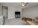 Spacious living room with light-colored carpet, a ceiling fan, TV, and a plush leather sofa at 21590 Violet Periwinkle Dr, Land O Lakes, FL 34637
