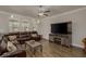 Cozy living room featuring a sectional sofa, wood-look floors, and a modern entertainment center, perfect for relaxation at 21590 Violet Periwinkle Dr, Land O Lakes, FL 34637