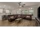 Open-concept living area with a sectional sofa, wood-look floors, and views of the kitchen and dining spaces at 21590 Violet Periwinkle Dr, Land O Lakes, FL 34637