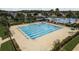 Community pool with ample seating, multiple swim lanes, diving blocks, and surrounding manicured landscaping at 21590 Violet Periwinkle Dr, Land O Lakes, FL 34637