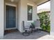 Inviting front porch with seating, a stylish door, and charming details creating a welcoming entrance to the home at 21590 Violet Periwinkle Dr, Land O Lakes, FL 34637