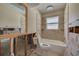 Bathroom featuring a toilet, tub with tiled surround, exposed framing, and window with natural light at 219 Miramar Ne Blvd, St Petersburg, FL 33704