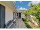 Exterior view of home entrance showcasing a tiled walkway, garden and a bench at 219 Miramar Ne Blvd, St Petersburg, FL 33704