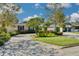 Single-Gathering home with a luscious front yard garden, an expansive driveway, and a two-car garage at 219 Miramar Ne Blvd, St Petersburg, FL 33704