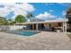 Exterior view of a backyard pool with patio, chairs, and outdoor kitchen at 219 Miramar Ne Blvd, St Petersburg, FL 33704