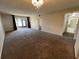 Expansive living room with plush carpeting, access to the screened-in lanai, and neutral wall colors at 229 Mary Dr # 229, Oldsmar, FL 34677