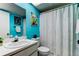 Bathroom featuring blue walls, a vanity, decorative art, and a shower with a curtain at 2600 Forest Run Ct, Clearwater, FL 33761