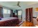 Bedroom with grey walls, a ceiling fan, hardwood floors, and draperies at 2600 Forest Run Ct, Clearwater, FL 33761