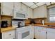The kitchen shows white appliances, tiled floors, and lots of white cabinets at 2600 Forest Run Ct, Clearwater, FL 33761