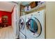Laundry room with large washer and dryer set and overhead shelving at 2600 Forest Run Ct, Clearwater, FL 33761