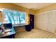 Bright office space showcasing a long desk by a sunny window and closet with louvered doors at 2600 Forest Run Ct, Clearwater, FL 33761