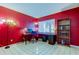 Vibrant office space with red walls, a built-in desk, and lots of natural light from the window at 2600 Forest Run Ct, Clearwater, FL 33761