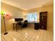 Bright office space featuring a long desk, a stool, tile floors, and a bookshelf by a sunny window at 2600 Forest Run Ct, Clearwater, FL 33761