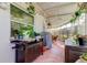 Enclosed patio featuring tile flooring, grill and outdoor furniture surrounded by hanging and potted plants at 2600 Forest Run Ct, Clearwater, FL 33761