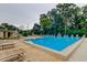 Community pool with a sundeck and ample seating surrounded by mature trees at 2600 Forest Run Ct, Clearwater, FL 33761