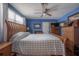 Cozy bedroom showcasing a wooden bed frame, blue walls, and a ceiling fan for added comfort at 2613 Upton S St, Gulfport, FL 33711